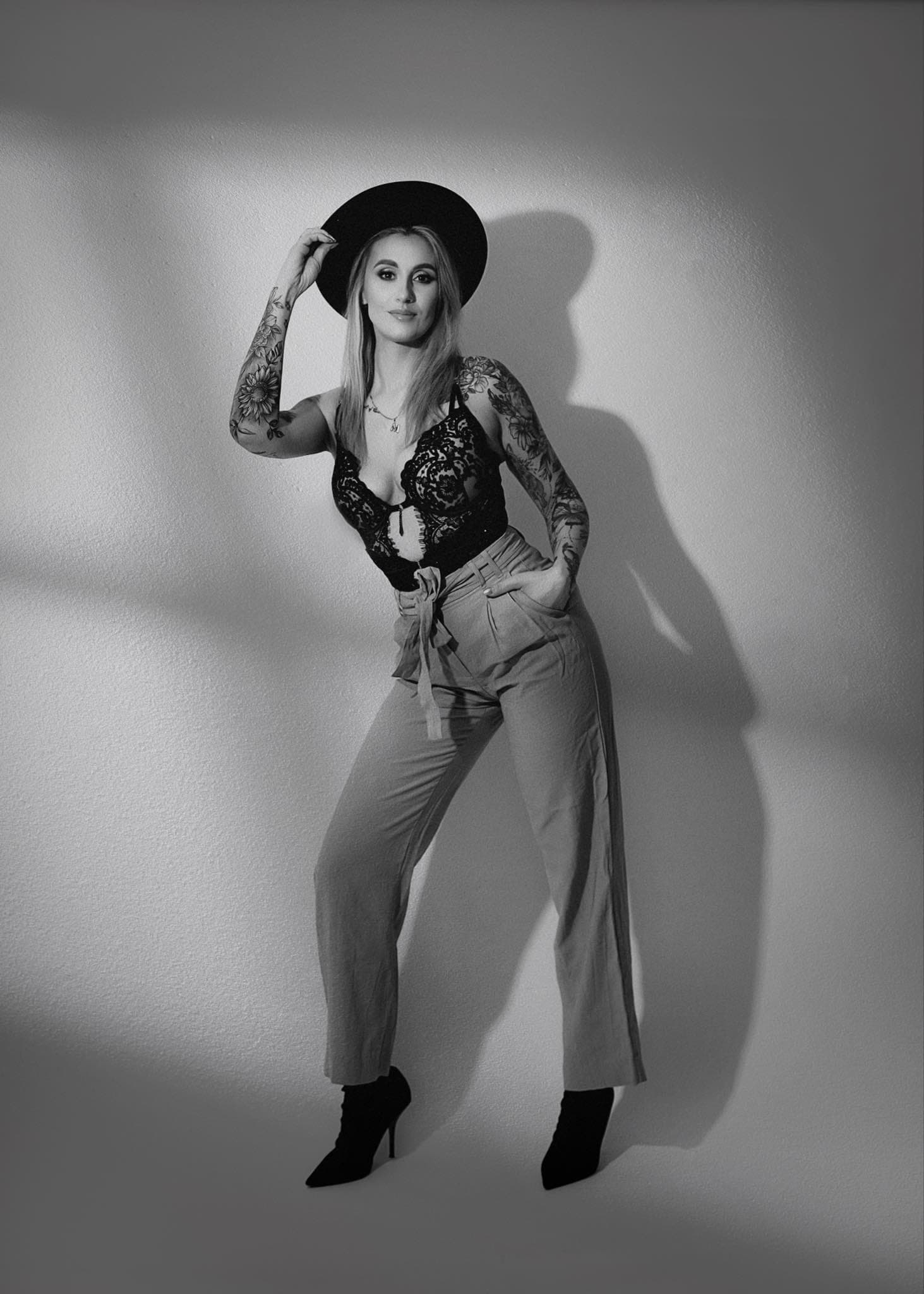 Karolina Gosz in a cinematic monochrome portrait with hat styling, wall shadow and a composed beauty mood