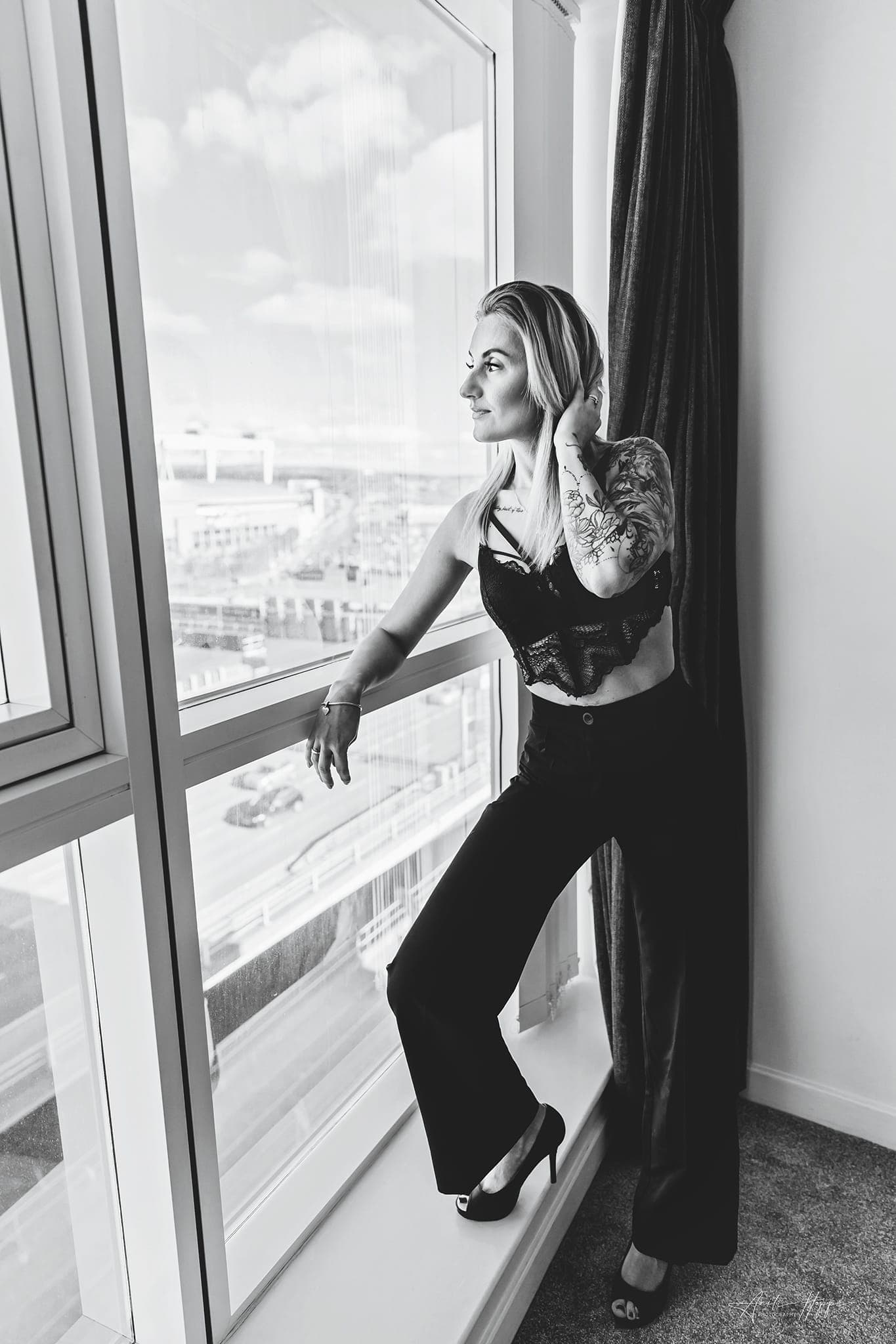 Karolina Gosz in a monochrome fashion portrait beside a city window with reflective light and composed styling